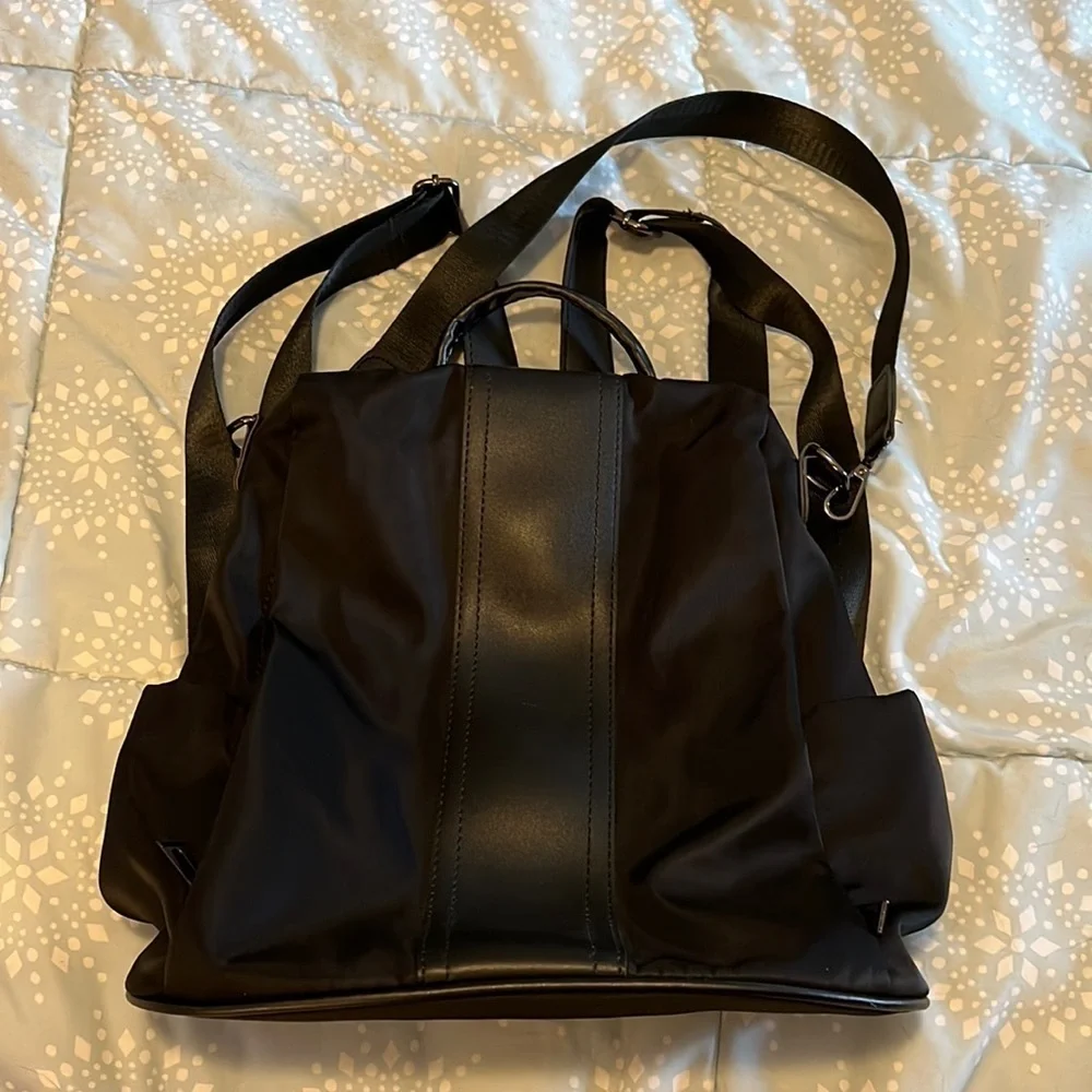 Black backpack, with strap and handle.